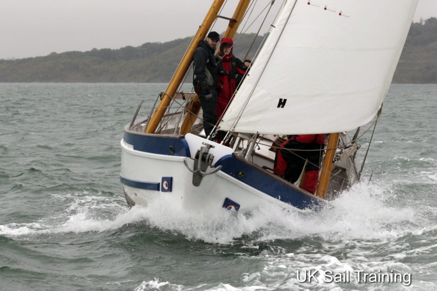 Boleh under sail with an impressive bow wave