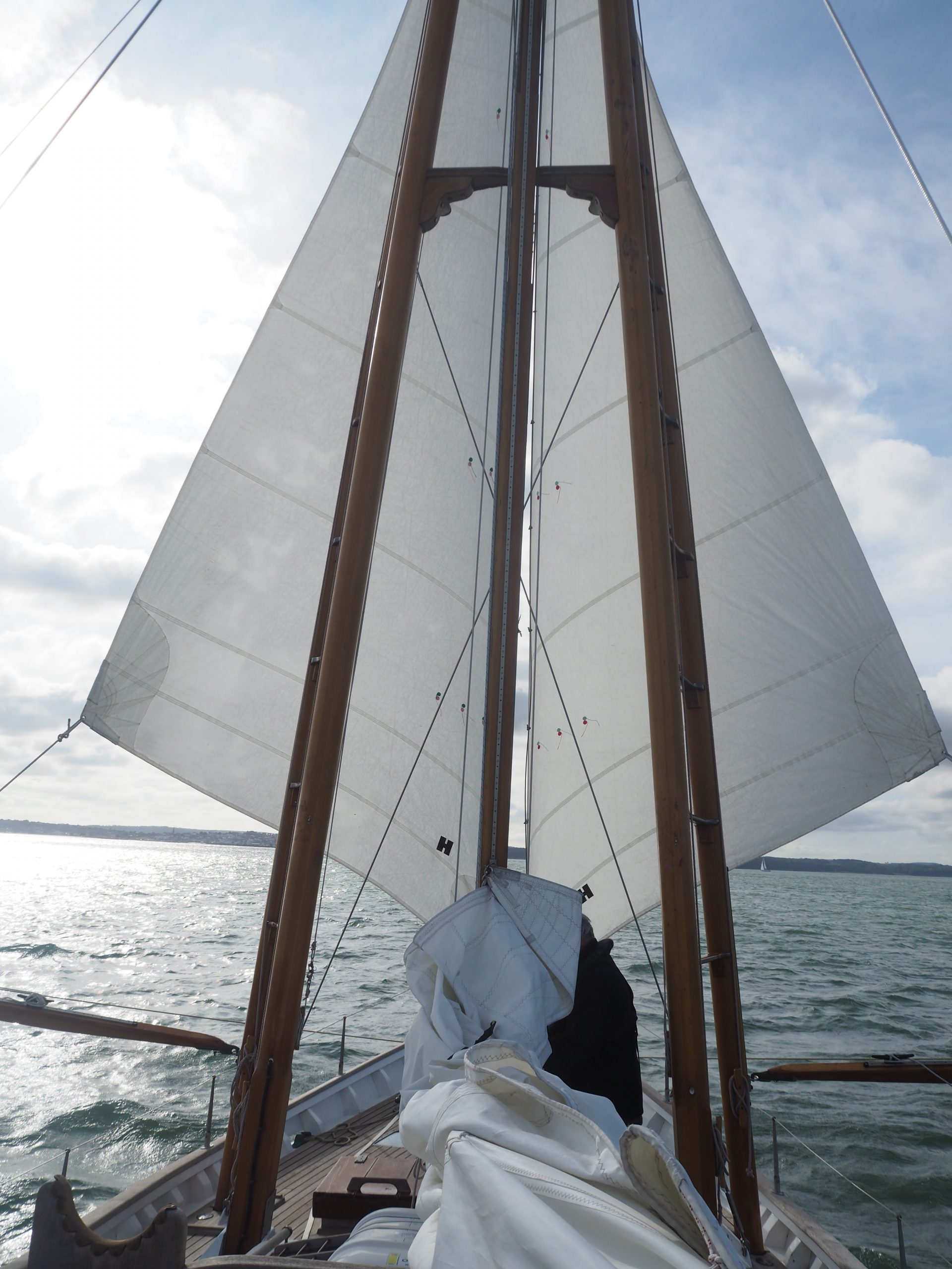 Boleh heading downwind, sporting her signature rig of boomed-out headsails and with a hint of sunshine ahead.